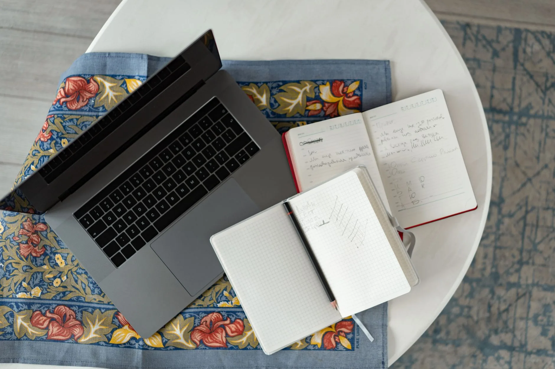 Laptop, notebooks and a pen on a desk — writing and articles